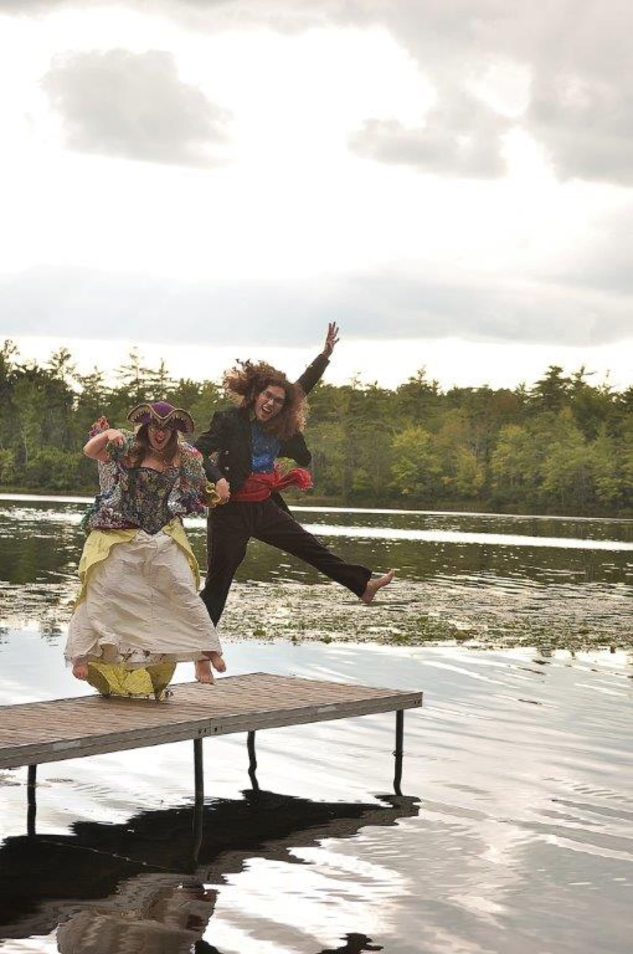 Two guests in costume jumping off the dock on Long Lake