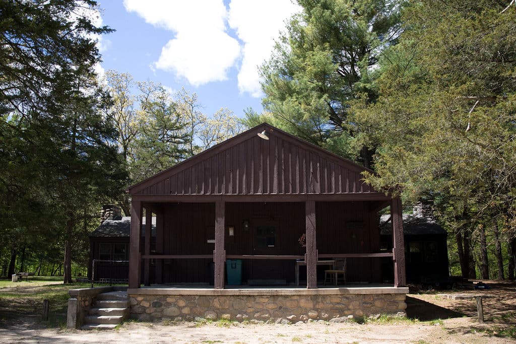 The lodge at Long Lake, a timber building with a covered porch among the pines